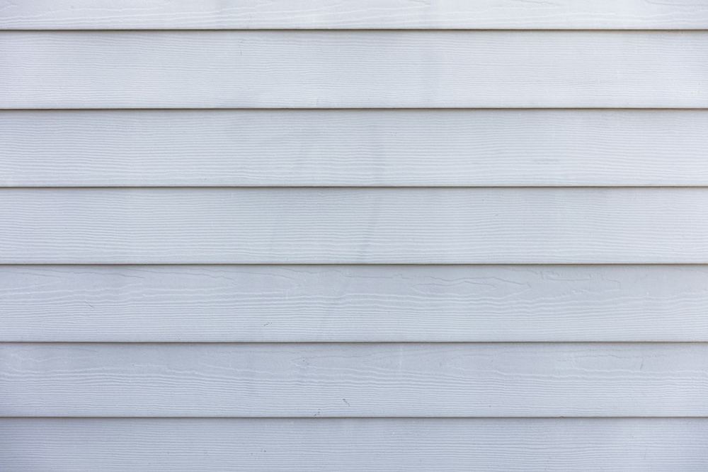 Close-up of clean white lap siding with even horizontal shadow lines